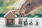House placed on coins Men's hand is planning savings money of coins to buy a home concept concept for property ladder, mortgage and real estate investment. for saving or investment for a house,; Shutterstock ID 1170707221; purchase_order: 131; job: ; client: ; other: 